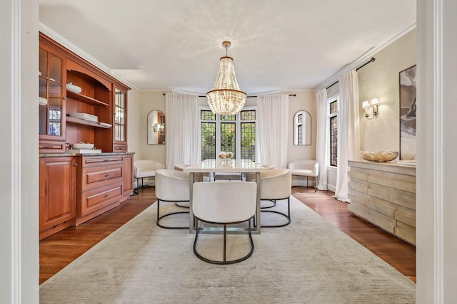 dining space with crown molding, dark hardwood / wood-style flooring, and a notable chandelier