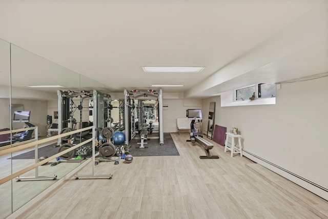 gym with a baseboard heating unit and hardwood / wood-style flooring