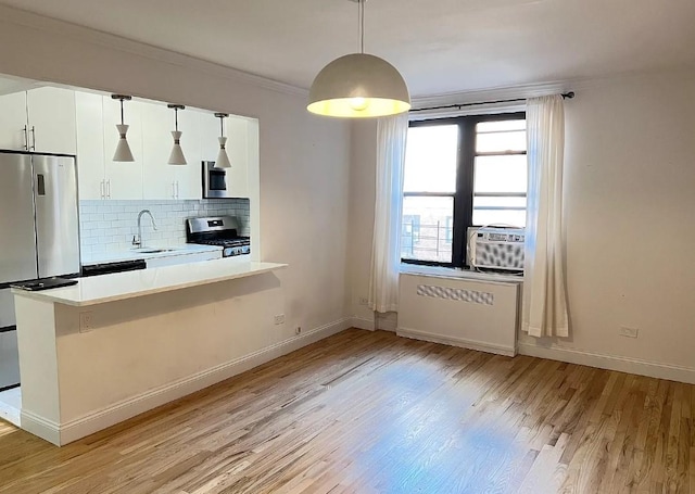 kitchen featuring white cabinetry, backsplash, light hardwood / wood-style floors, decorative light fixtures, and appliances with stainless steel finishes