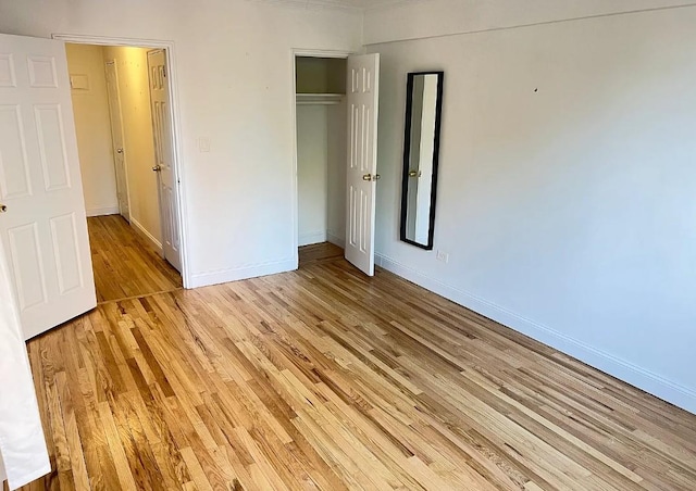 unfurnished bedroom featuring light wood-type flooring and a closet