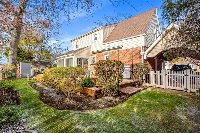 rear view of property featuring a yard and a wooden deck