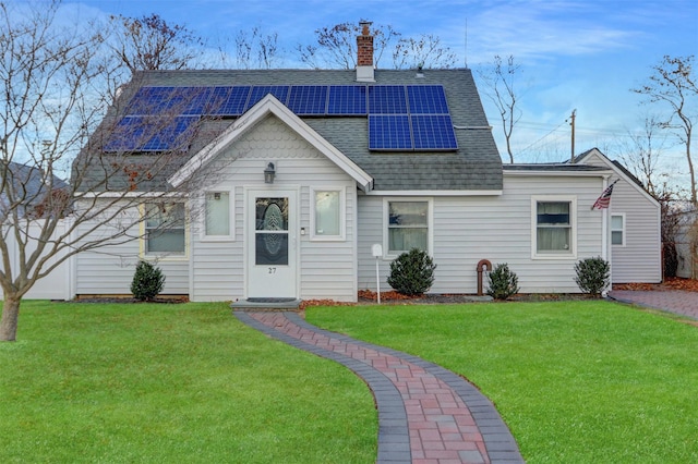 view of front of property featuring solar panels and a front yard
