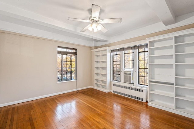 empty room with beamed ceiling, radiator heating unit, ceiling fan, and hardwood / wood-style floors