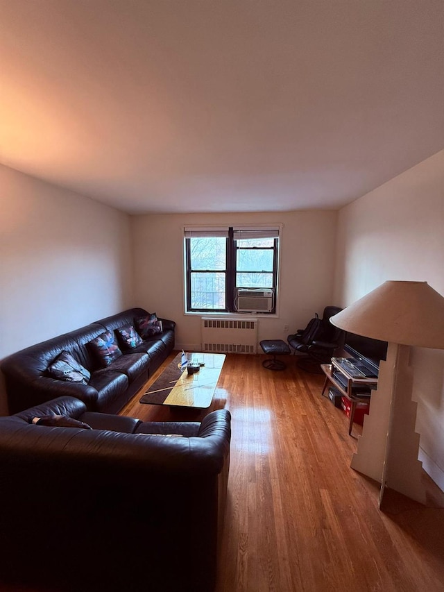 living room featuring radiator heating unit, cooling unit, and hardwood / wood-style floors