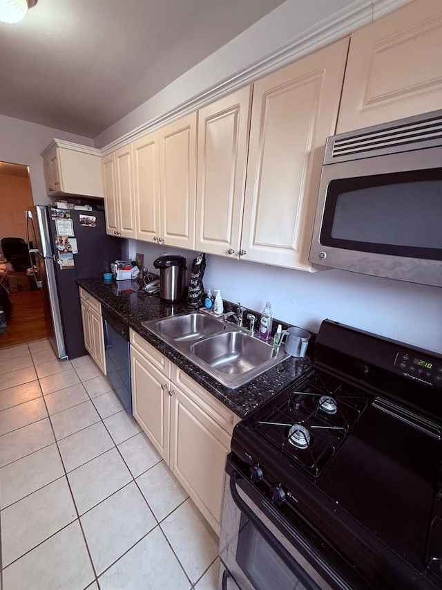 kitchen featuring black appliances, light tile patterned floors, sink, and cream cabinetry