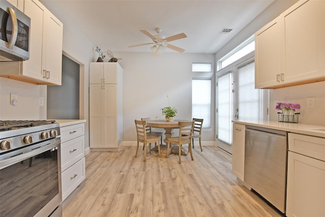 kitchen featuring white cabinetry, ceiling fan, light hardwood / wood-style floors, and appliances with stainless steel finishes