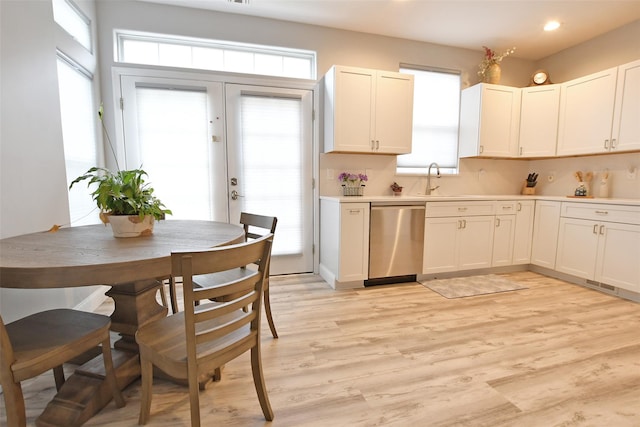 kitchen with a healthy amount of sunlight, white cabinets, and stainless steel dishwasher