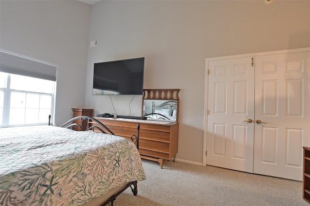 bedroom featuring light colored carpet and a closet