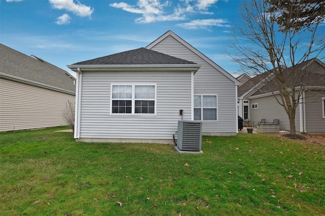 rear view of house with a lawn and central air condition unit