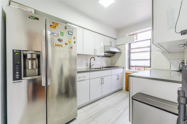 kitchen with white cabinetry, sink, backsplash, light tile patterned floors, and appliances with stainless steel finishes