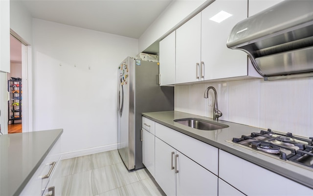 kitchen featuring stainless steel refrigerator, white cabinetry, sink, white gas cooktop, and exhaust hood