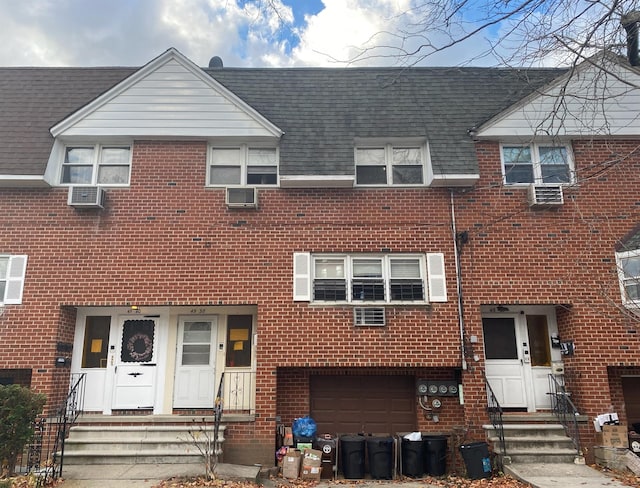 view of front of property featuring a wall mounted air conditioner and a garage