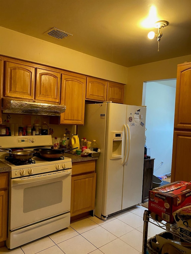 kitchen with light tile patterned floors and white appliances