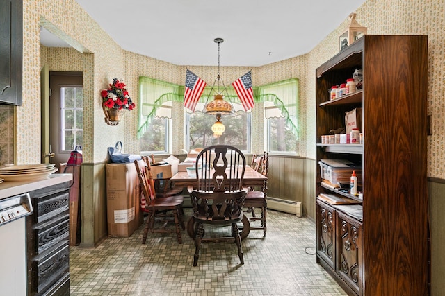 dining room featuring wood walls and baseboard heating