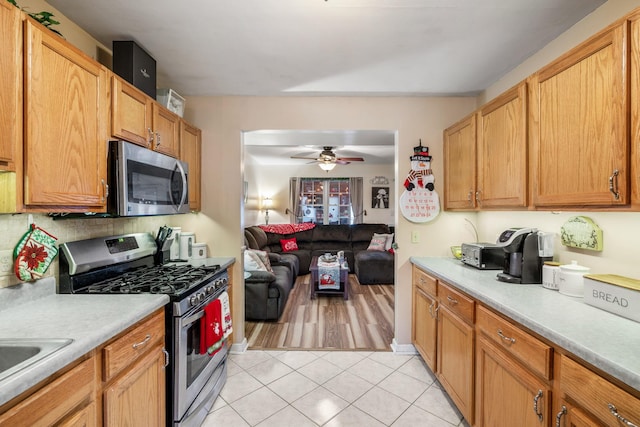 kitchen with ceiling fan, sink, light tile patterned floors, and appliances with stainless steel finishes