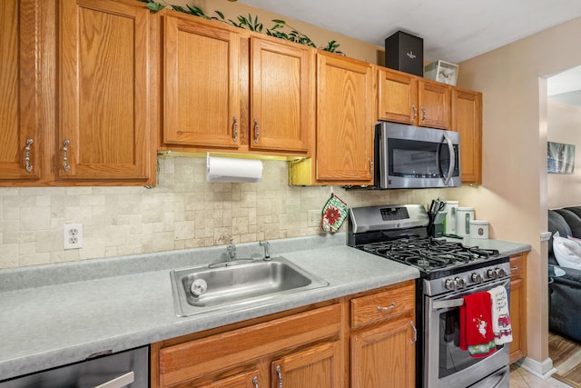 kitchen featuring light hardwood / wood-style floors, sink, appliances with stainless steel finishes, and tasteful backsplash