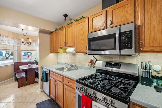 kitchen featuring tasteful backsplash, stainless steel appliances, sink, light tile patterned floors, and an inviting chandelier