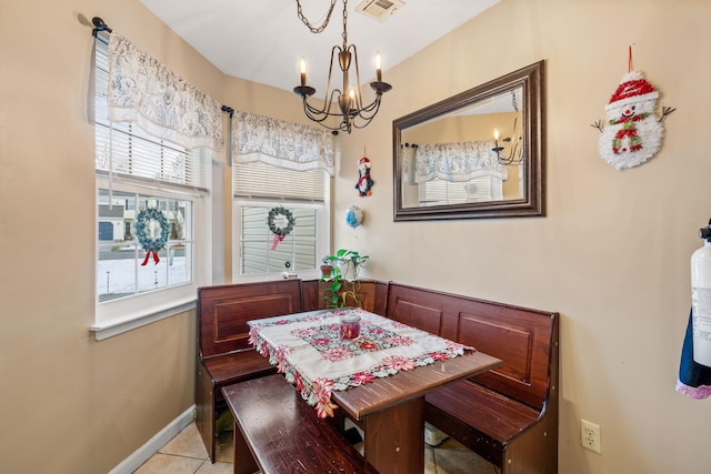 tiled dining area with an inviting chandelier