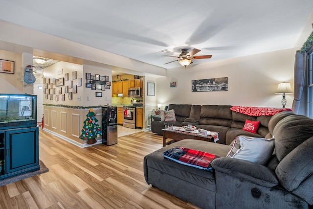 living room with ceiling fan and light hardwood / wood-style flooring