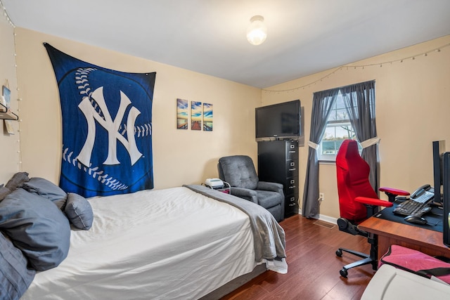 bedroom with dark hardwood / wood-style flooring