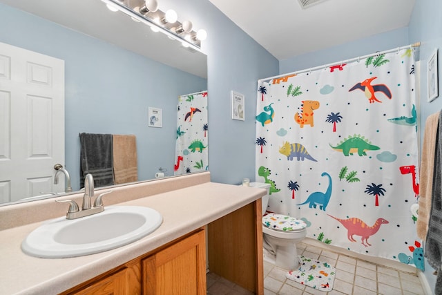 bathroom featuring tile patterned flooring, vanity, toilet, and walk in shower