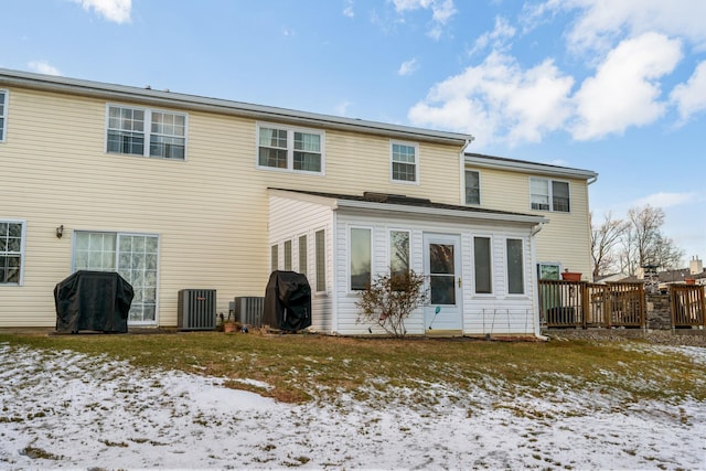 snow covered rear of property featuring central air condition unit