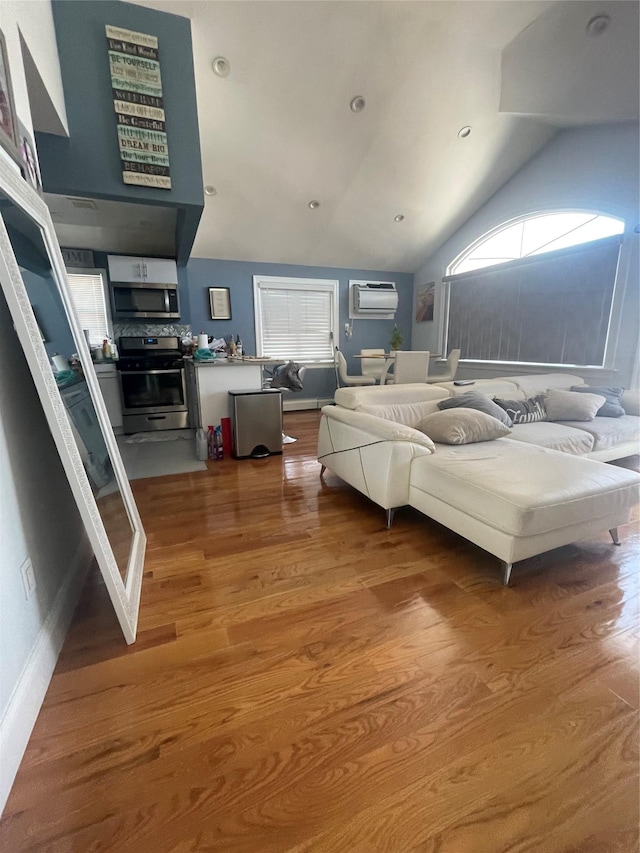 bedroom featuring lofted ceiling, a wall mounted AC, and wood-type flooring