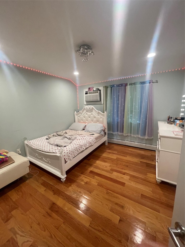 bedroom featuring a wall mounted AC and light wood-type flooring