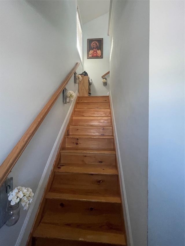 staircase featuring lofted ceiling