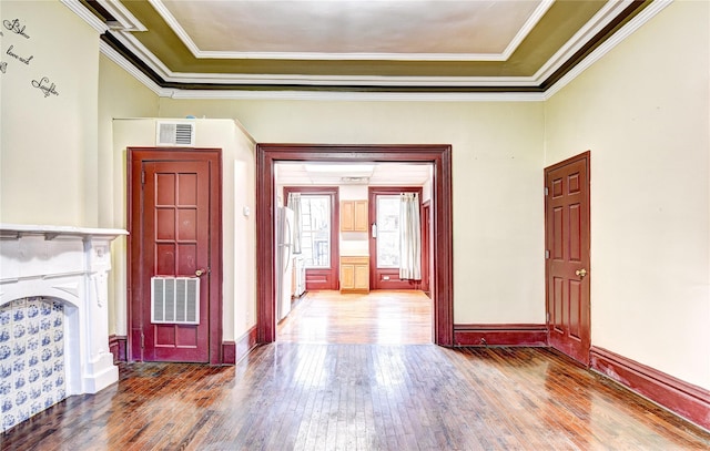 hall featuring a tray ceiling, crown molding, and hardwood / wood-style flooring