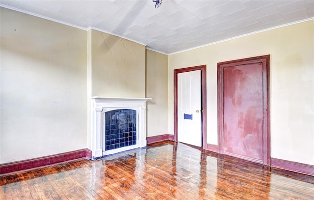 unfurnished living room with crown molding and hardwood / wood-style flooring