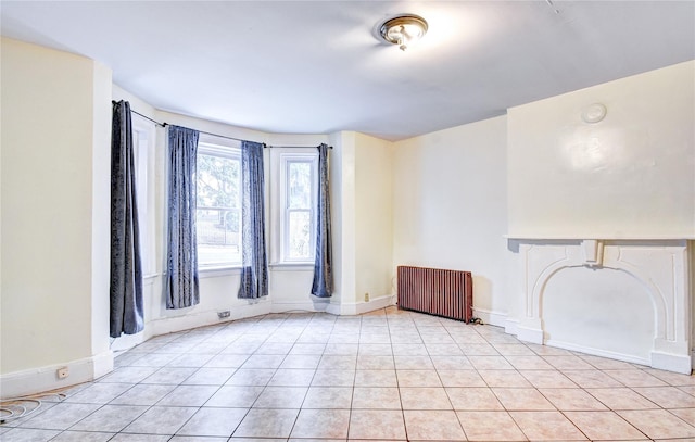 tiled spare room with radiator heating unit