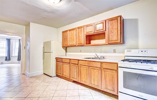 kitchen featuring sink, light tile patterned floors, and white appliances