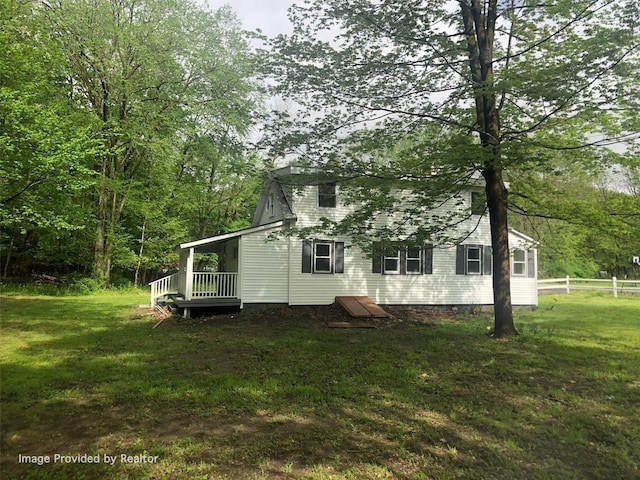 rear view of property featuring a yard