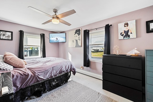 bedroom with ceiling fan and a baseboard heating unit