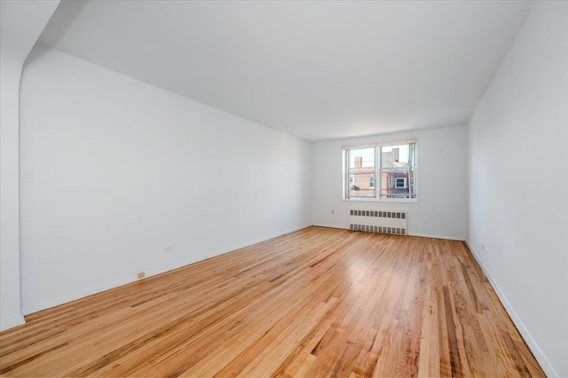 unfurnished room featuring light hardwood / wood-style floors and radiator