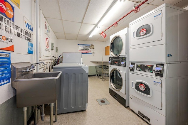 clothes washing area featuring sink, stacked washer / drying machine, and washing machine and clothes dryer