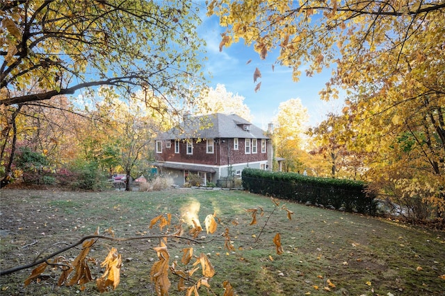 rear view of property with a yard and a fire pit