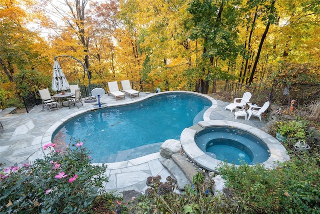 view of swimming pool with a patio area and an in ground hot tub