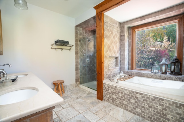 full bathroom featuring a shower stall, a garden tub, and a sink