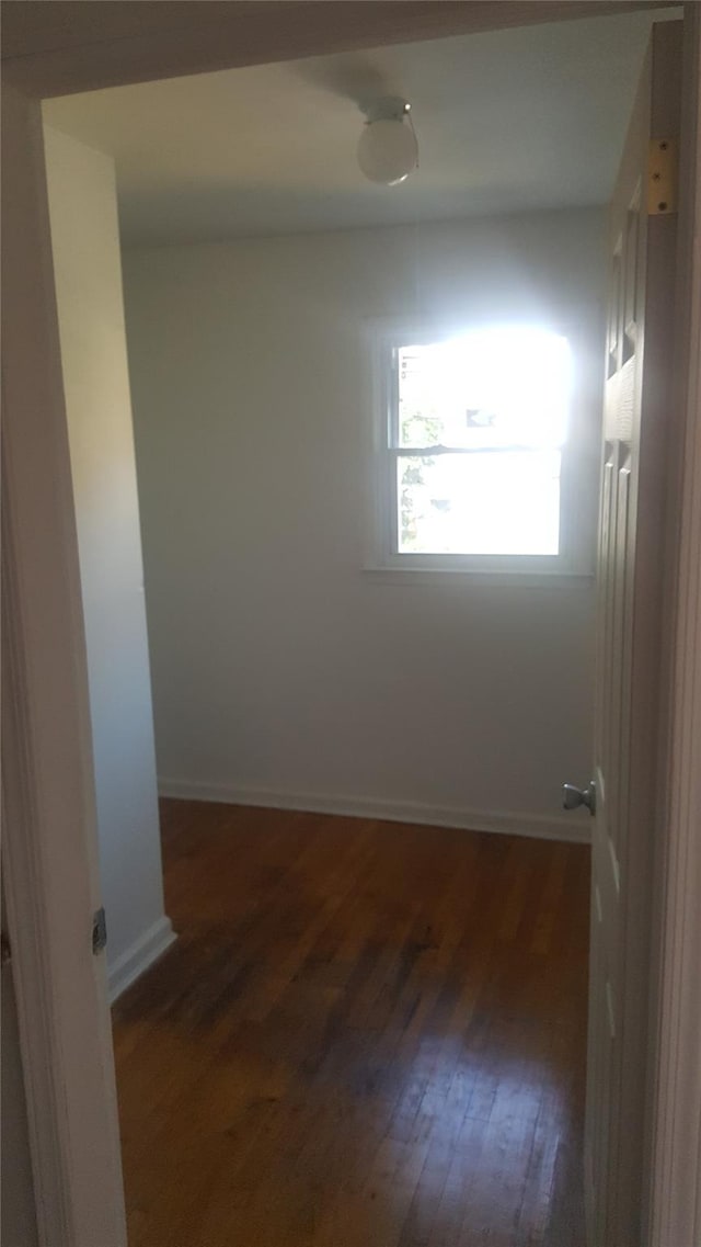 empty room with dark hardwood / wood-style flooring