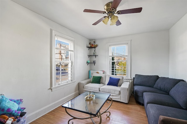 living room with ceiling fan and light hardwood / wood-style flooring