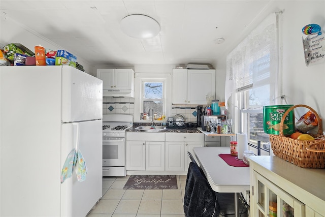 kitchen with sink, white appliances, white cabinetry, backsplash, and light tile patterned flooring