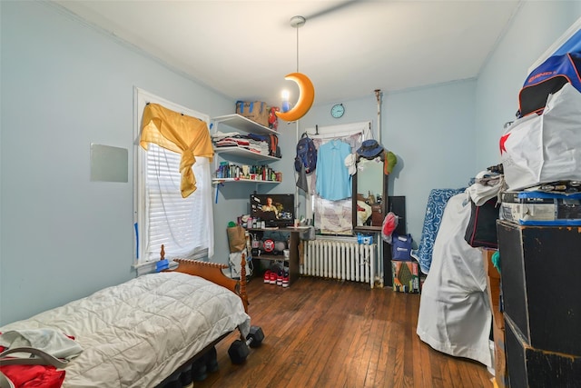 bedroom featuring radiator and dark hardwood / wood-style flooring