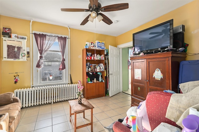 living room with radiator, light tile patterned floors, and ceiling fan