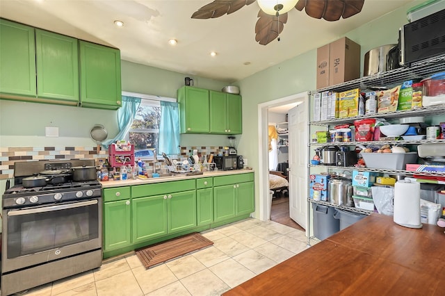 kitchen with tasteful backsplash, sink, wooden counters, green cabinetry, and stainless steel gas range oven