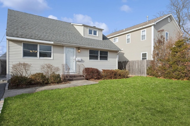 rear view of property featuring a lawn