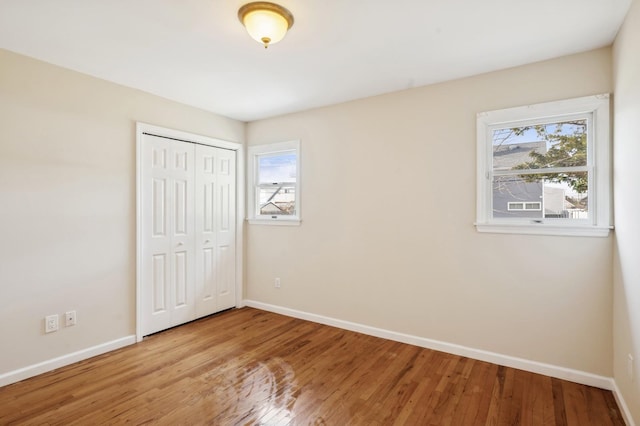 unfurnished bedroom with light hardwood / wood-style flooring and a closet