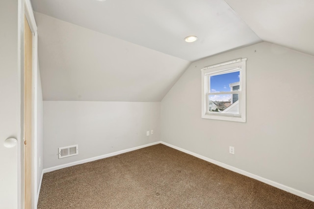 bonus room with carpet flooring and vaulted ceiling