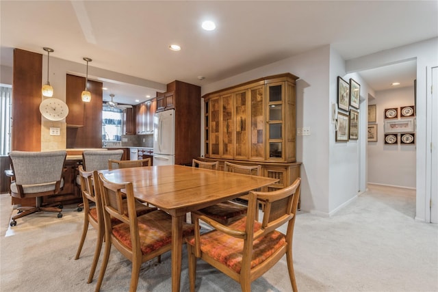 carpeted dining area featuring ceiling fan